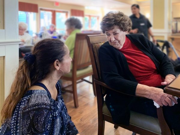 Greenhaven Place | Senior speaking with associate at table